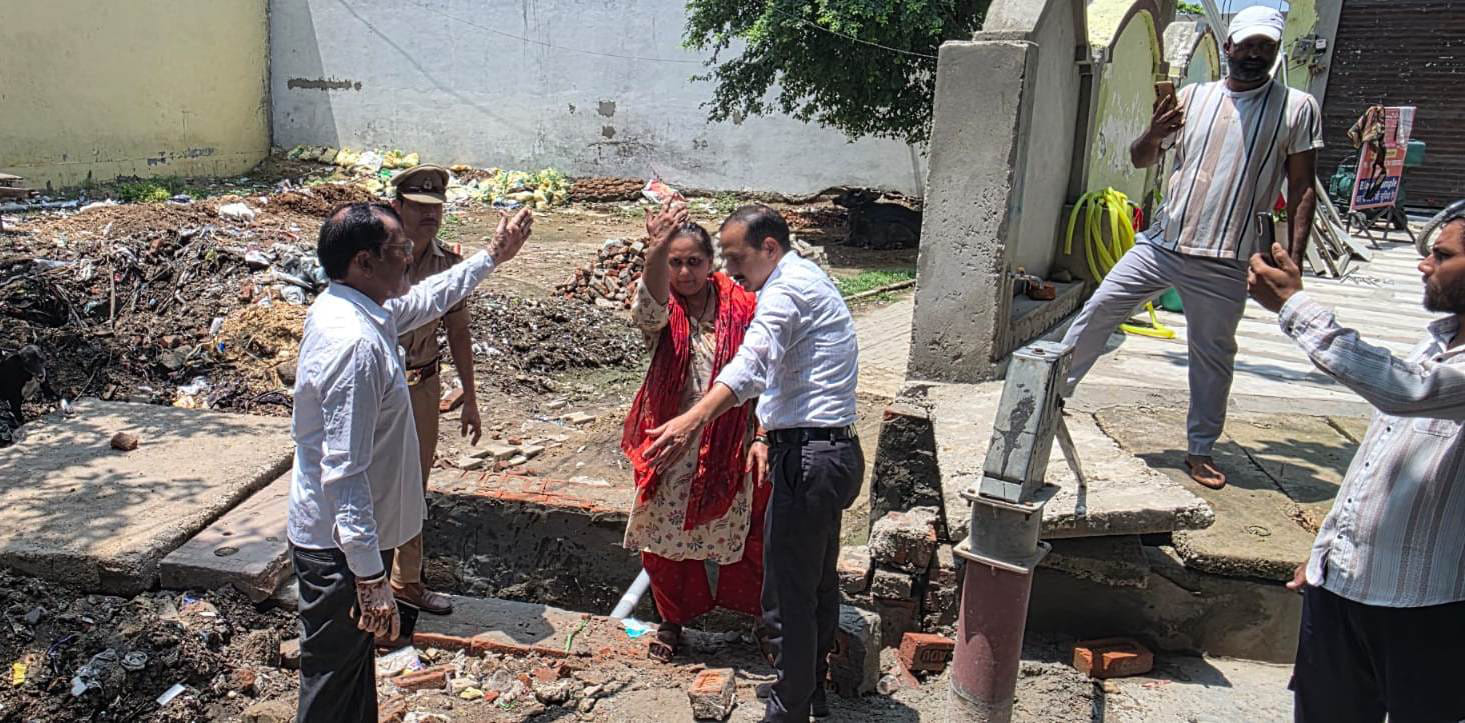 गढ़ में आत्मदाह के प्रयास के दौरान महिला को बचाते नायब तहसीलदार। संवाद
