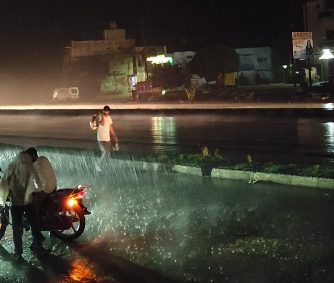 कमलापुर में बारिश के दौरान जलभराव से होकर निकलते लोग। संवाद