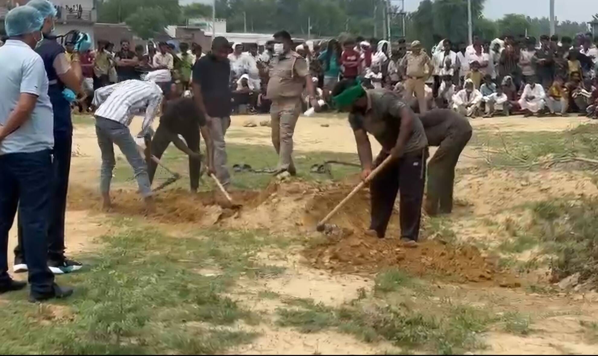 रियावली में कब्र खोदकर महिला के शव को निकालते ग्रामीण