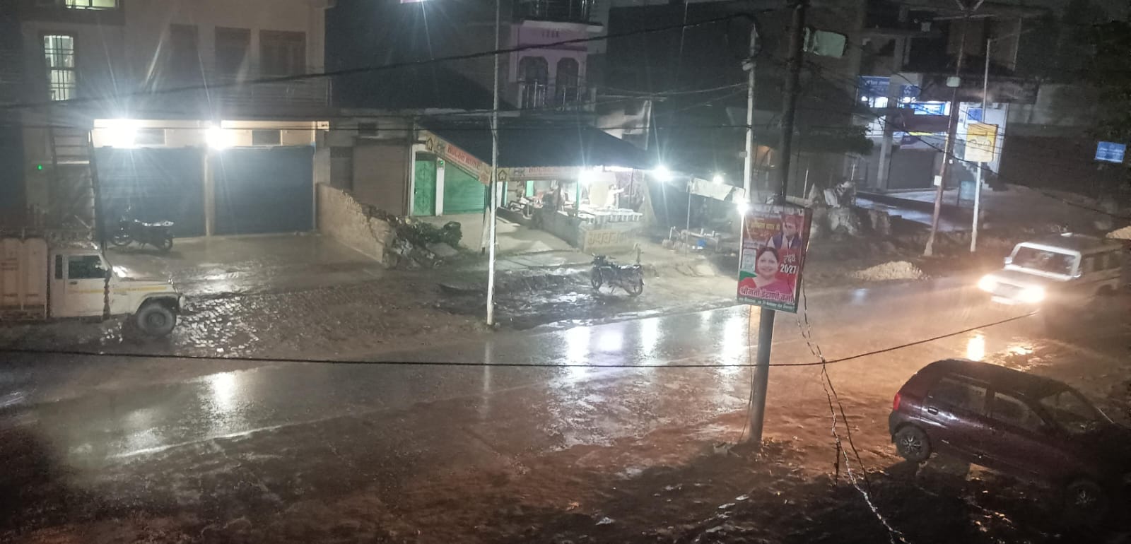  भिनगा में हो रही बारिश के बीच आते जाते लोग।