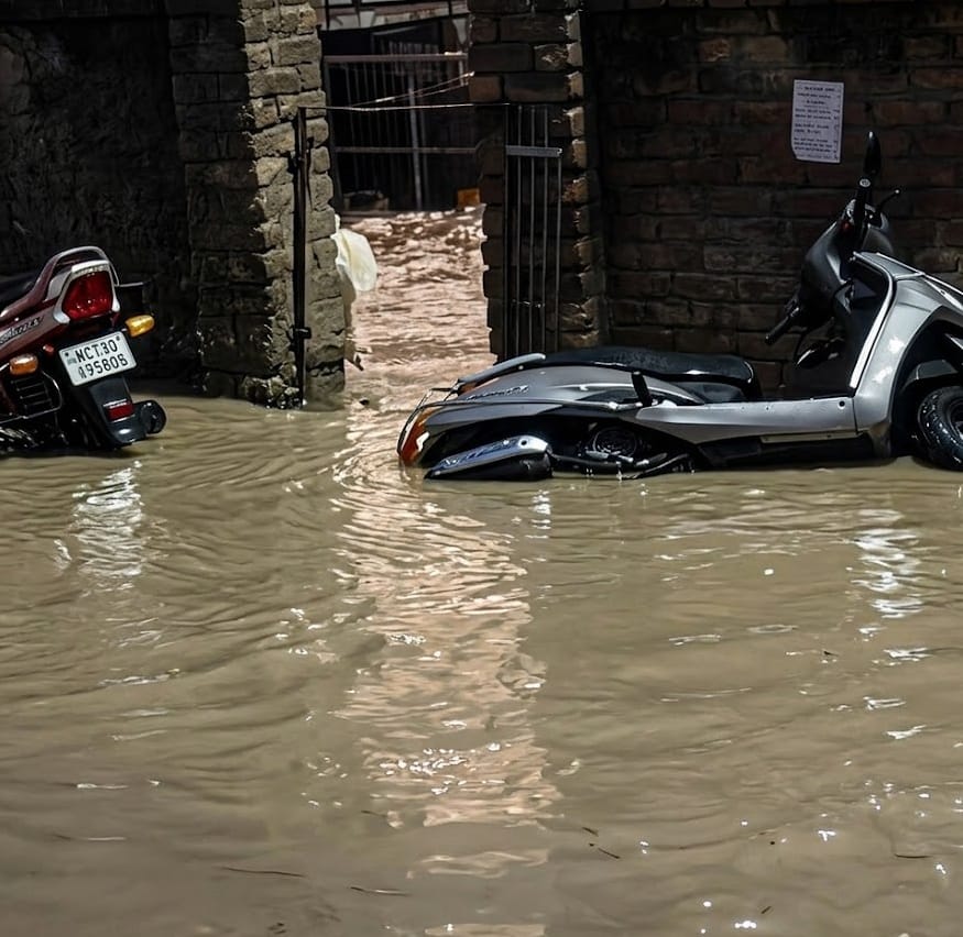 बनीखेत में भारी बारिश के दौरान फंसे वाहन व पानी में पैदल चलते लोग