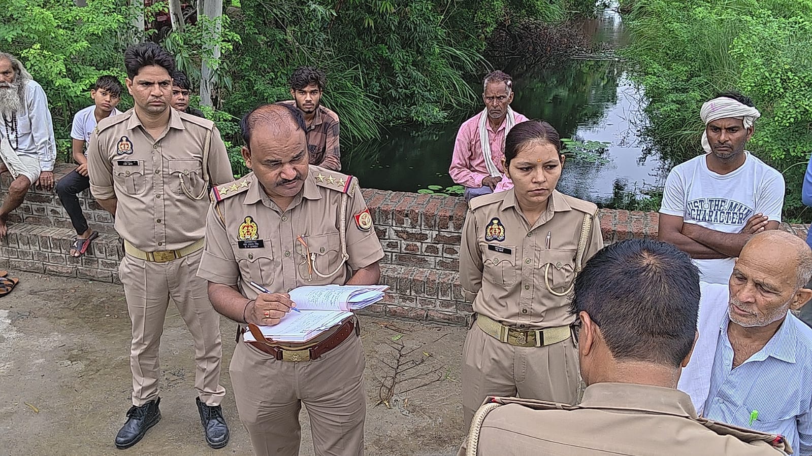 फोटो-12- घटनास्थल पर जांच करती पुलिस मौजूद ग्रामीण। संवाद