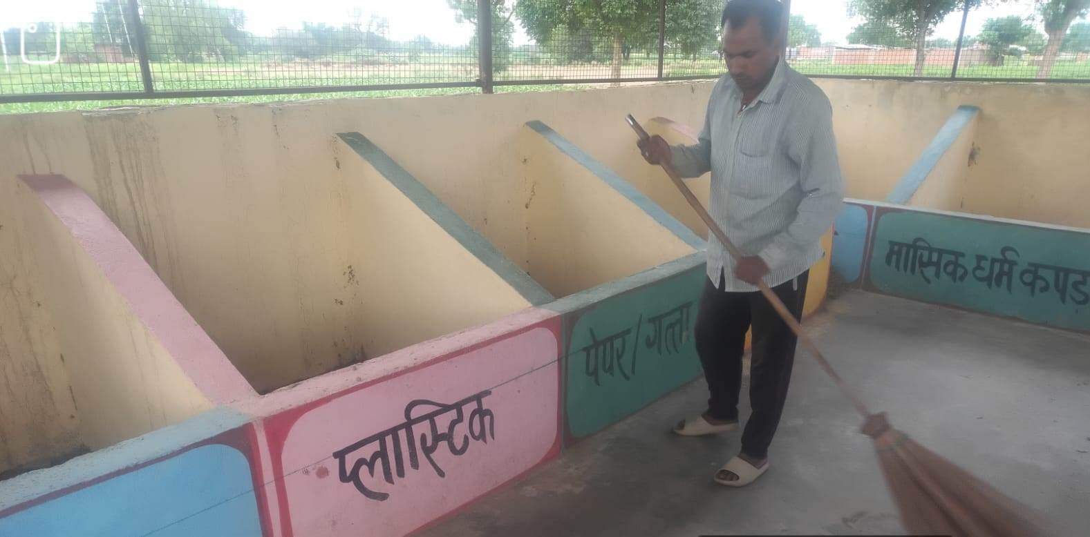 फोटो-13- आरआरसी सेंटर से पशु चारा हटाने के बाद सफाई करता कर्मी। संवाद