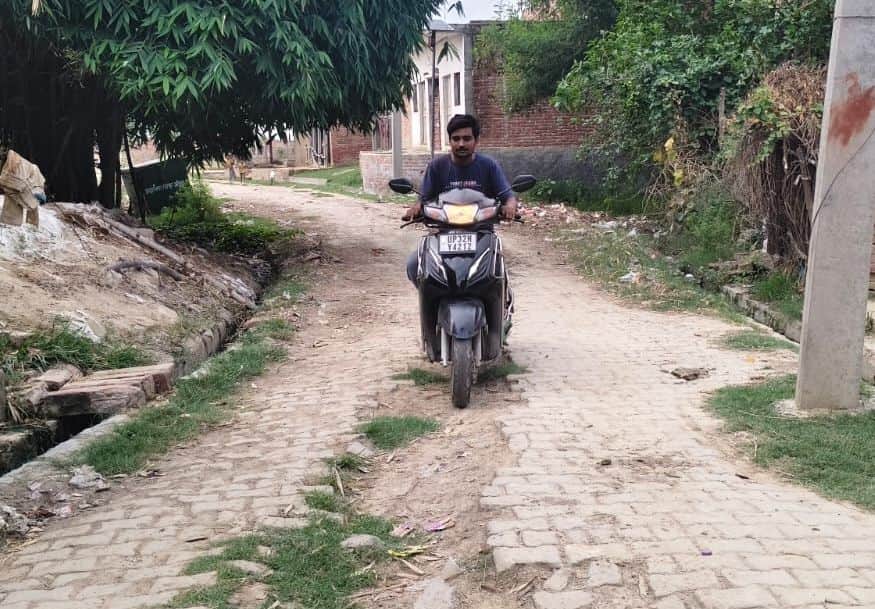 फोटो-2-नगर पंचायत औरास के चंद्रशेखर आजाद नगर में खराब पड़ी रोड से निकलता बाइक सवार। संवाद