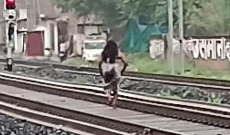 रेलवे ट्रैक पर दौड़ लगाती महिला।