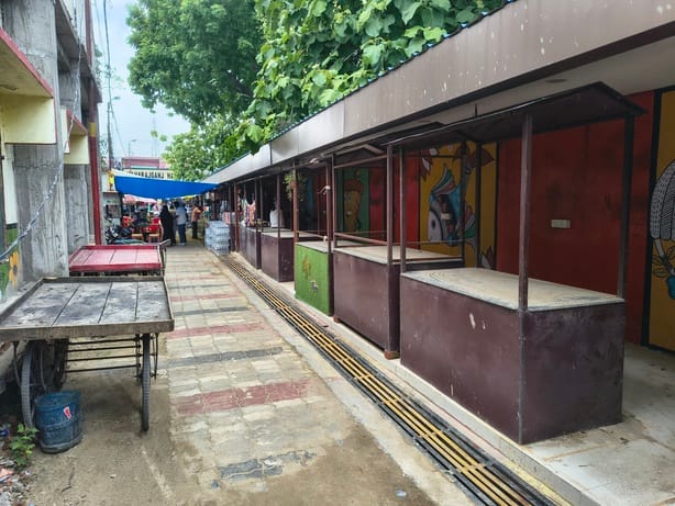Vending zones in name only; shops operating on the street.