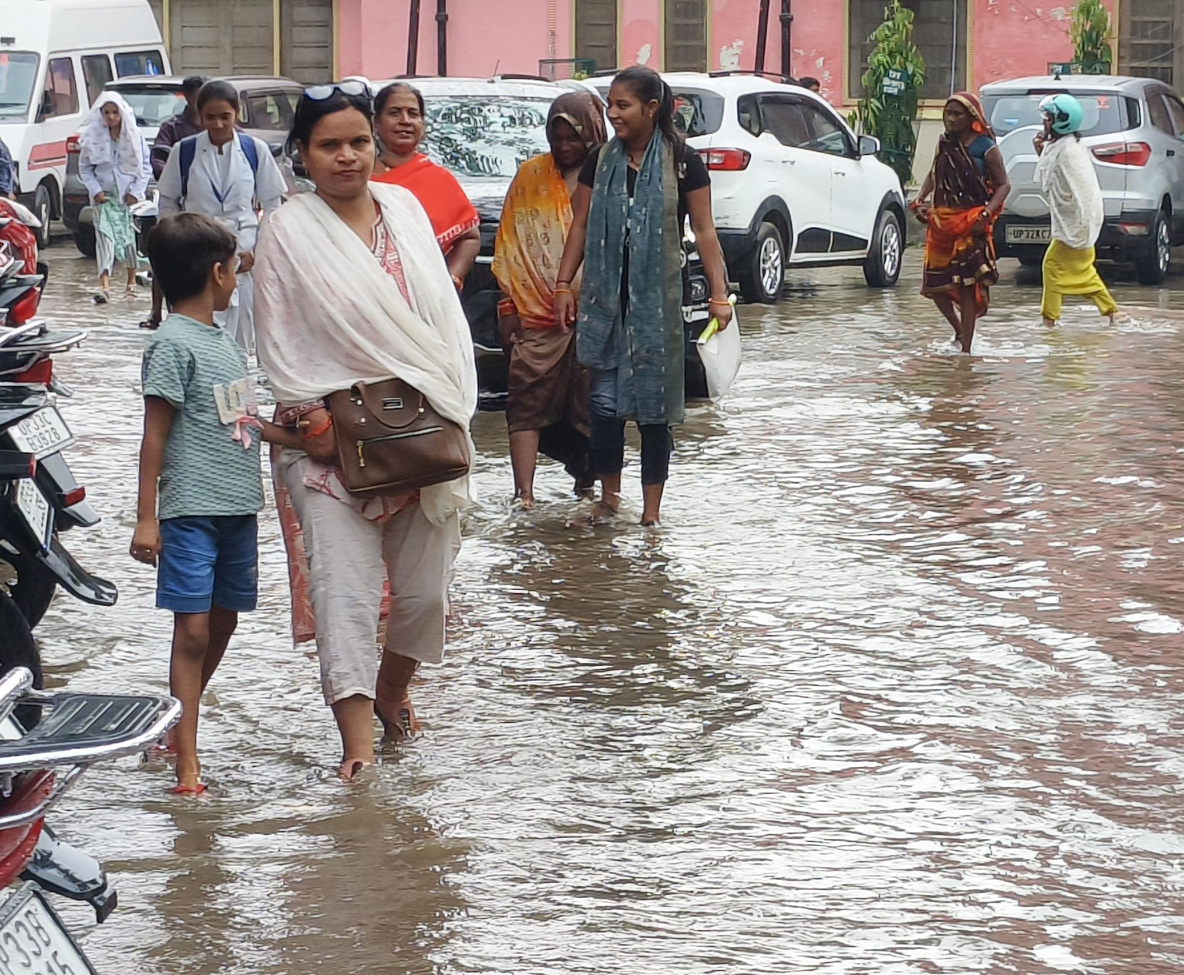 शहर में झमाझम हुई बारिश के बाद जिला अस्पताल परिसर में जलभराव से होकर निकलते मरीज व तीमारदार। 