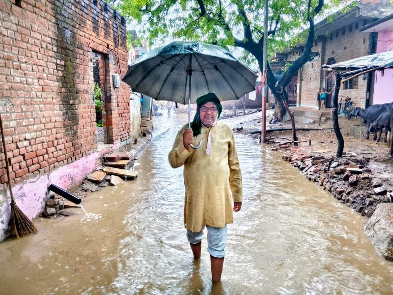 तिंदवारी कस्बे के शंकर नगर मोहल्ले में जलभराव के बीच निकला बुजुर्ग। संवाद