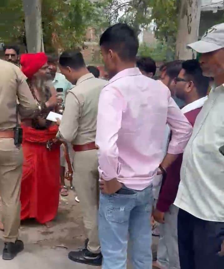 फोटो-32- हाईवे पर गाड़ियों में मवेशी पकड़े जाने के दौरान पुलिस कर्मियों से बातचीत करते जूना अखा