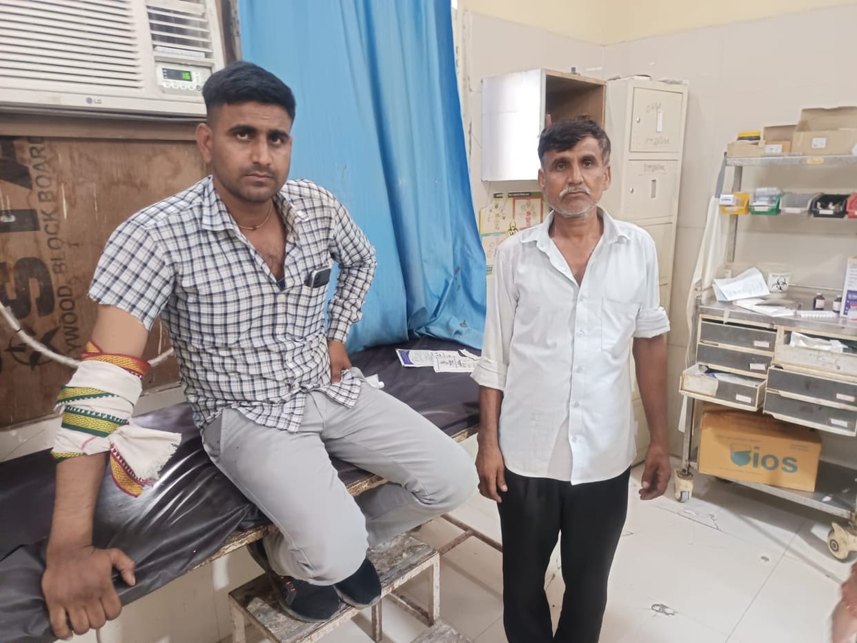 Father and son fired upon while on their way to court; young man hit in the hand.