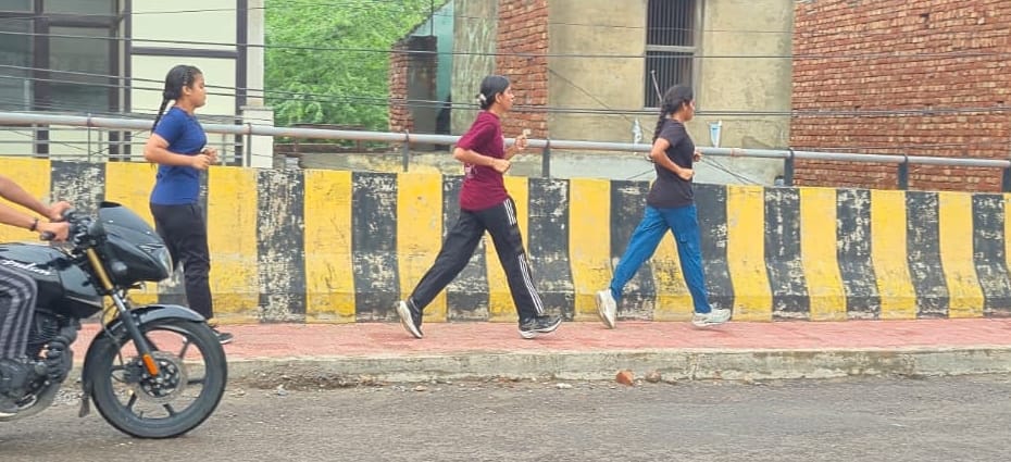 Waterlogging at Bhim Stadium; youths practicing running on the road.