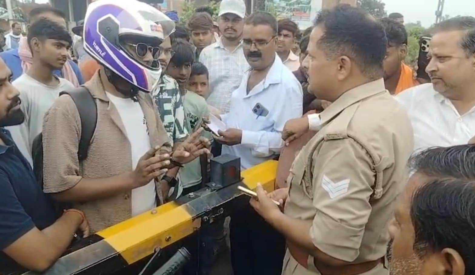 फोटो-21- रेलवे कर्मियों से बहस कर रहे लोगों को समझाती पुलिस। स्रोत: वीडियो