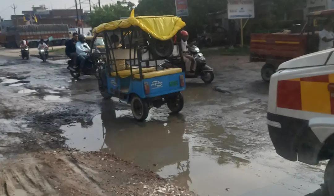 फोटो-33- मार्ग पर पानी से भरे गड्डों से गुजरते वाहन। संवाद