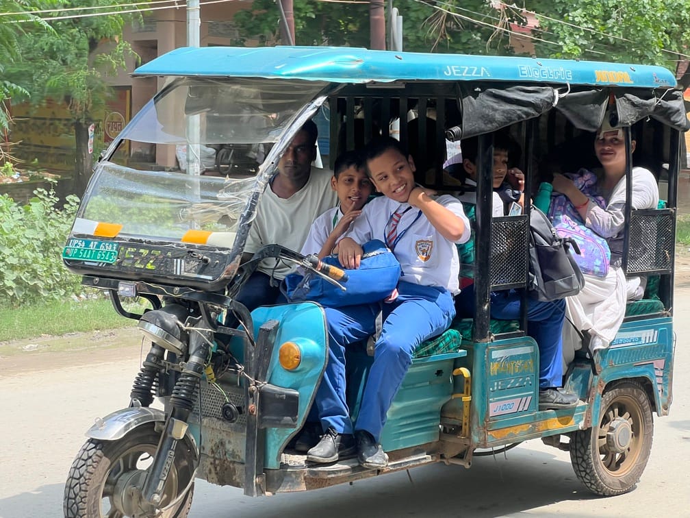 नगर के गाजीपुर तिराहा से होकर छुट्टी के बाद बच्चों को ई रिक्शा से लेकर घर जाता चालक।संवाद