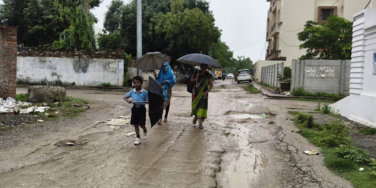 रॉबर्ट्सगंज में हल्की बारिश में छाता लगाकर निकली महिलाएं। संवाद