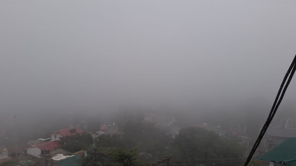 Tourist town enveloped in fog; vehicles crawled along with headlights on.