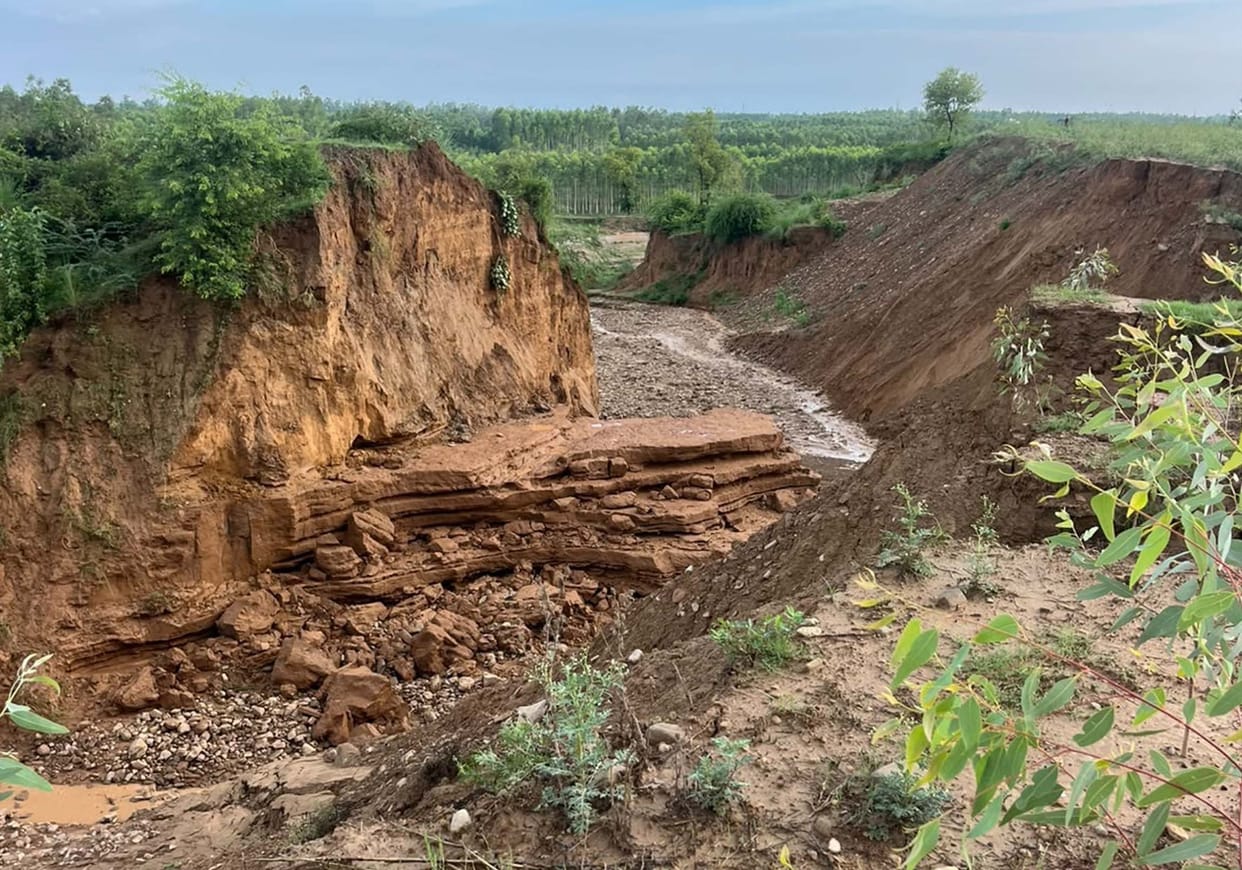 Soil erosion occurred as water failed to be retained by the damaged dam; sand deposited in the fields