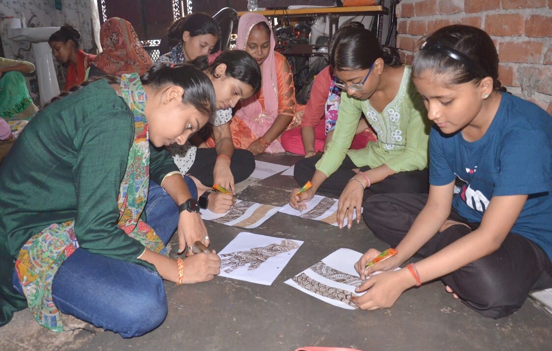 Women learning to apply henna ahead of Hariyali Teej