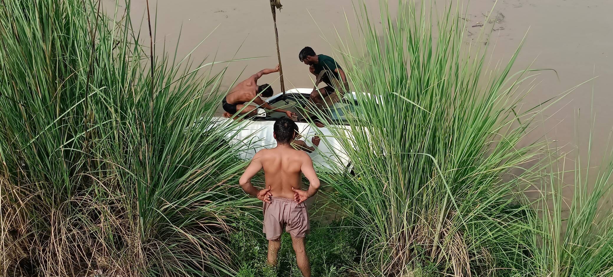 नहर से कार को निकालते गोताखोर। सोशल मीडिया