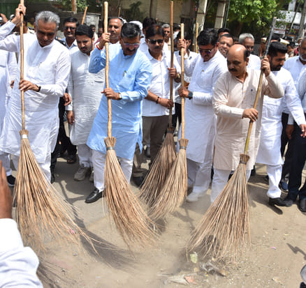 The minister conducted a cleanliness drive by sweeping alongside other leaders; meanwhile, garbage remained scattered at Hans Market until 12 noon