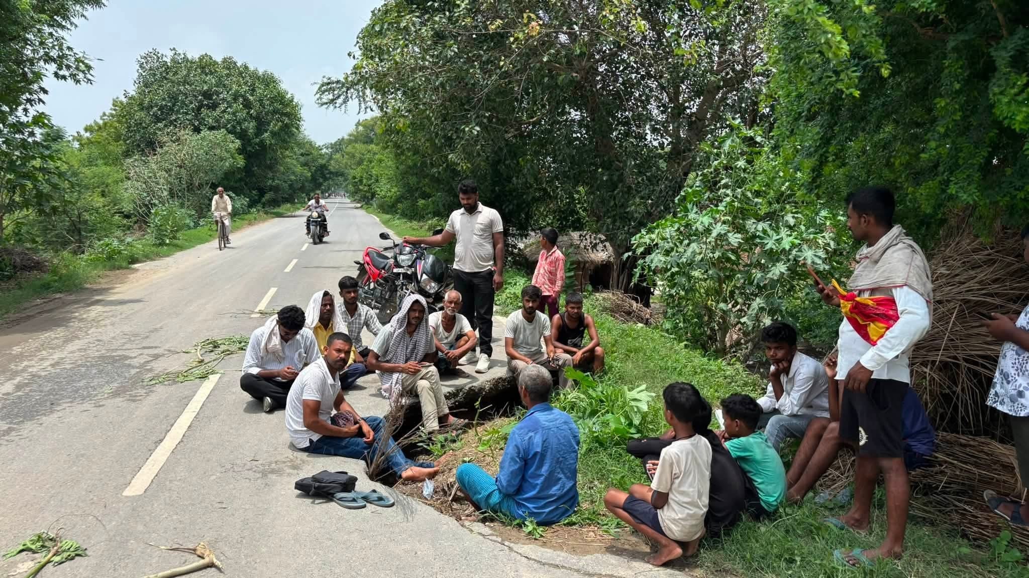 क्षतिग्रस्त मनियर-सिकंदरपुर मार्ग के मरम्मत की मांग को लेकर धरना पर बैठे युवा।आयोजक