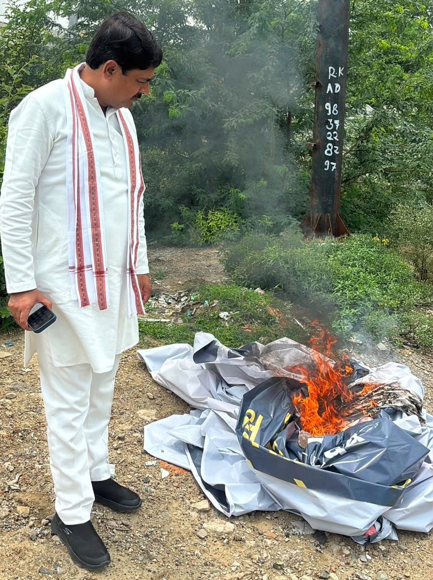 होर्डिंग जलाते सपा सांसद आनंद भदाैरिया। संवाद