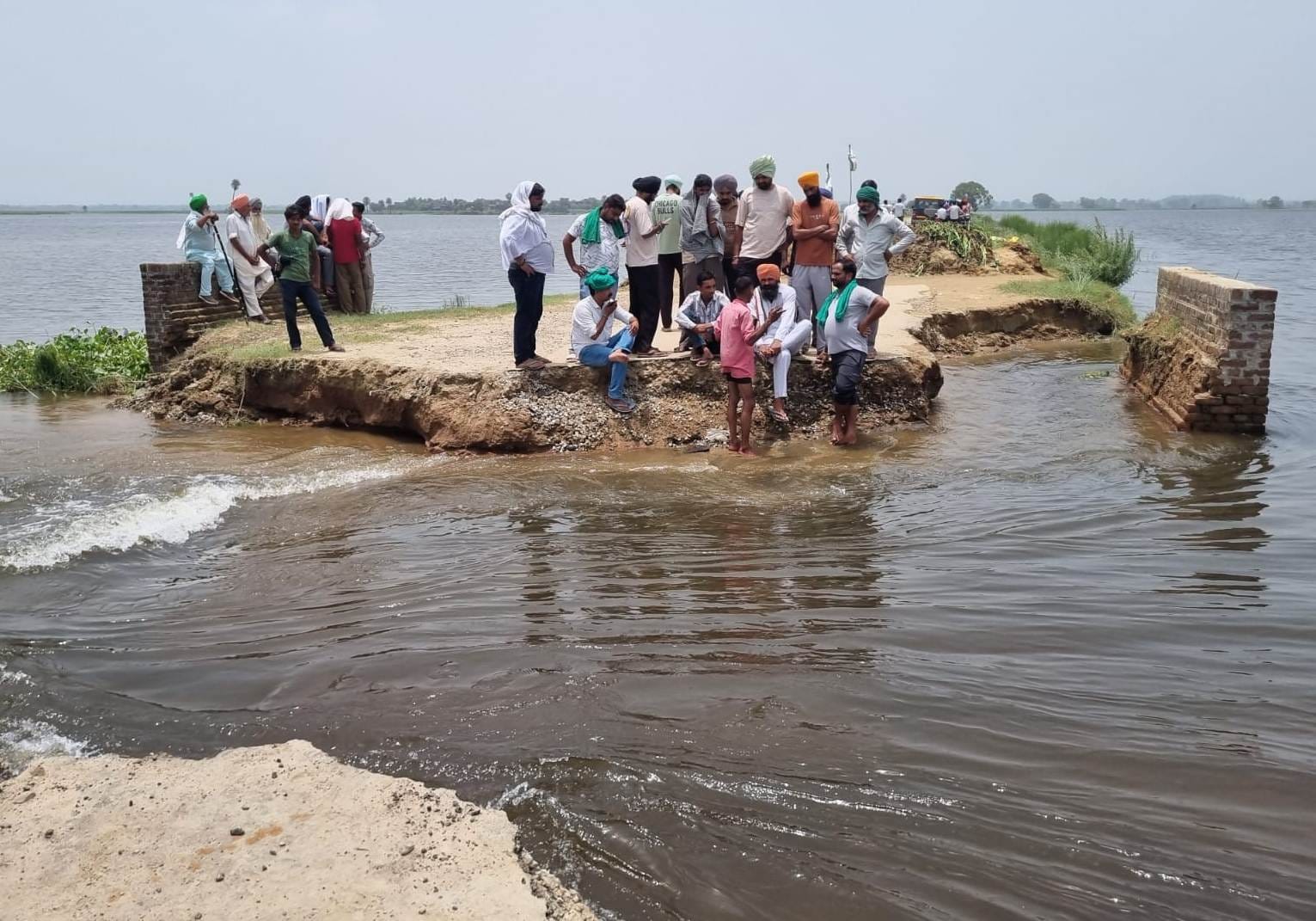 जलीलपुर हस्तिनापुर के बीच सड़क कटे स्थान पर बैठे क्षेत्रीय गांव वासी स्रोत संवाद
