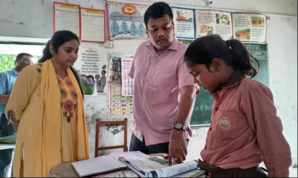 परसेंडी के ग्राम पीरपुर के उच्च प्राथमिक विद्यालय के निरीक्षण के दौरान छात्रा से किताब पढ़वाते