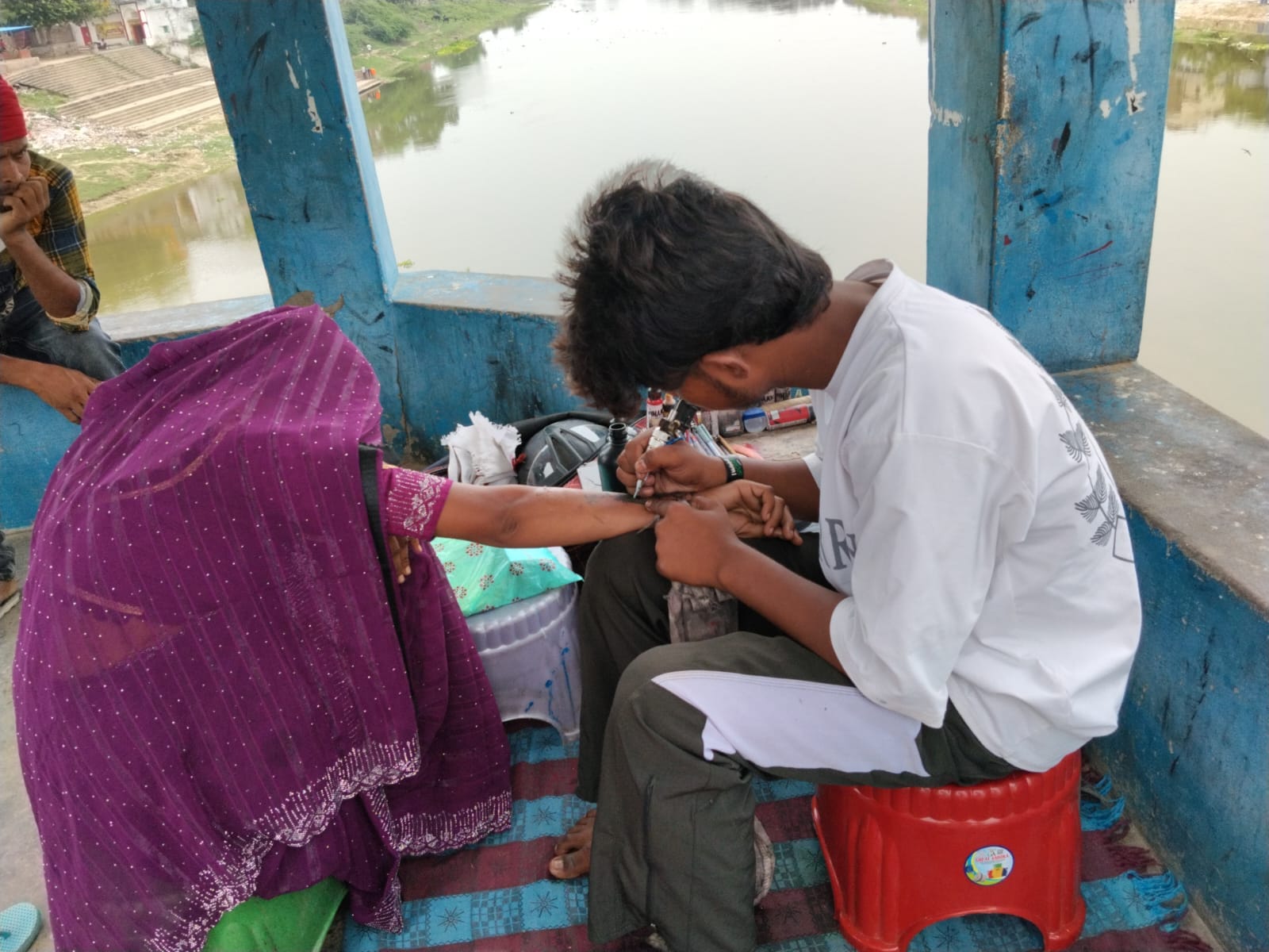 शाही पुल पर टैटू बनवाती महिला। संवाद