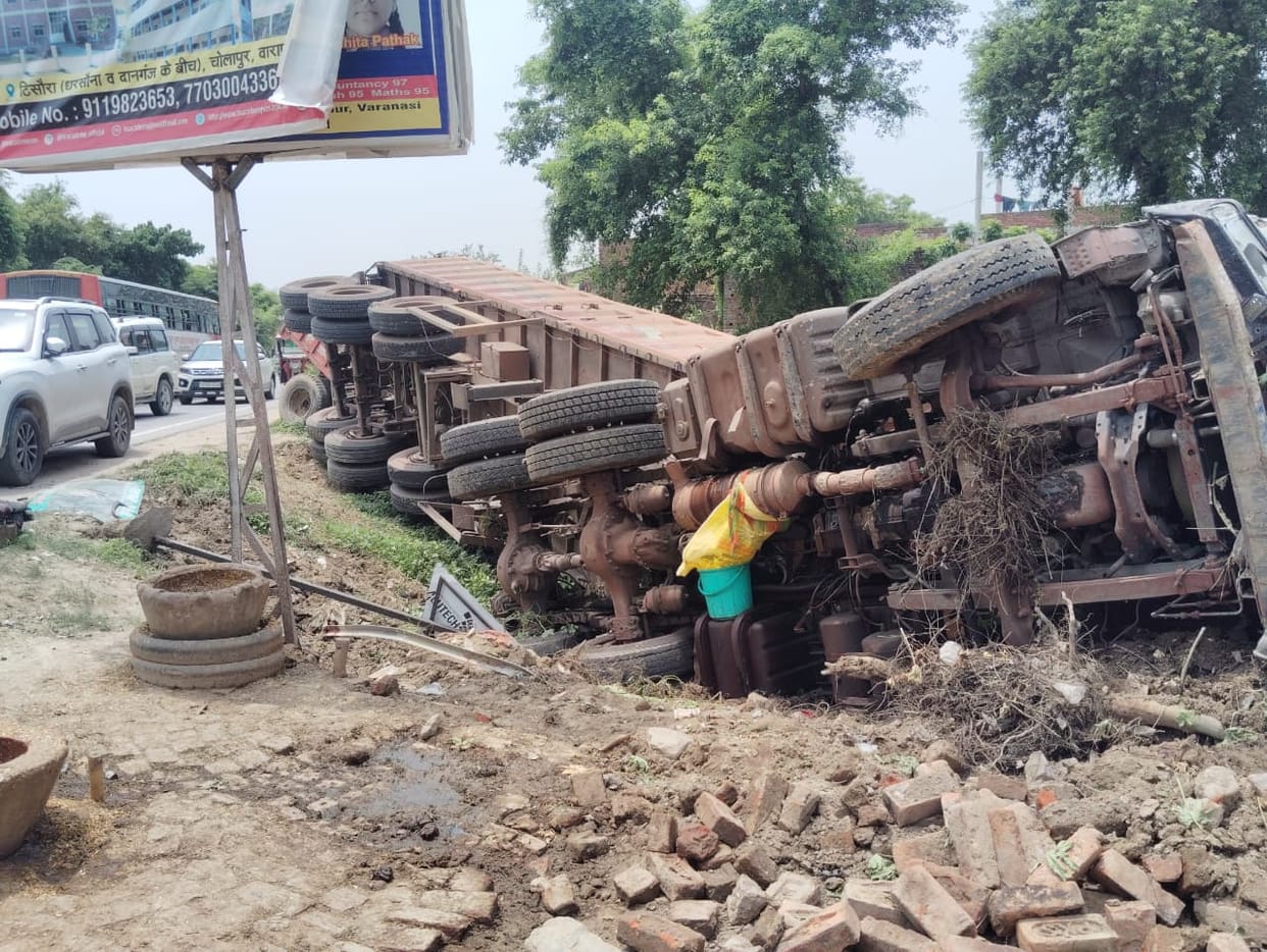 Out-of-control trailer overturns; tractor crushed underneath; helper critically injured.