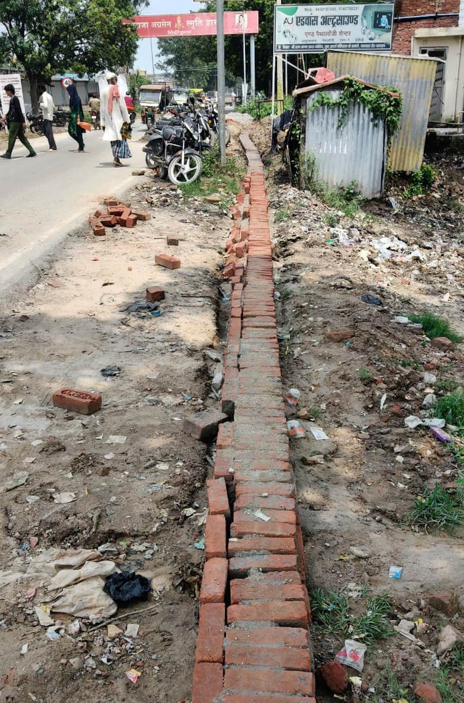 मिहींपुरवा नगर पंचायत की ओर से कराया जा रहा सड़क के किनारे इंटरलॉकिंग का कार्य।