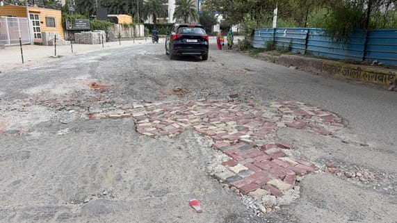 The road leading to the glitzy society is in a dilapidated state.
