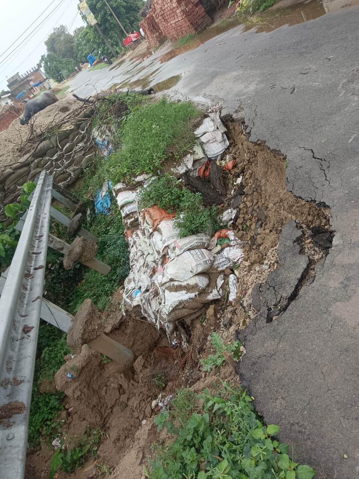 Road begins to cave in due to rain; traffic disrupted.
