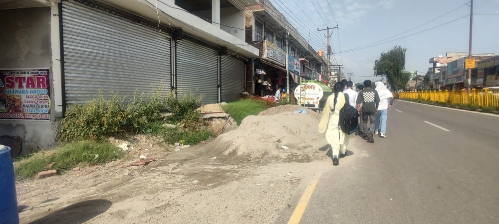 Construction work complete, yet sand and gravel remain scattered on the main road.