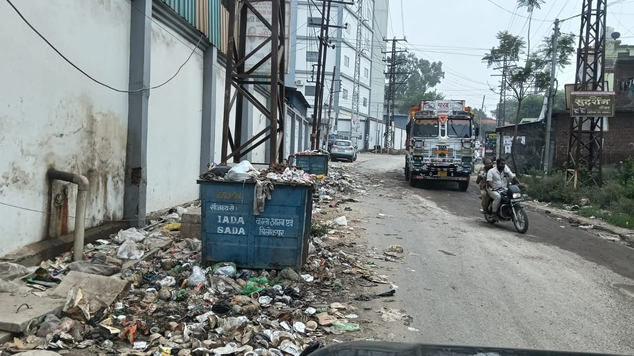 Dustbins overflowing; garbage scattered here and there.