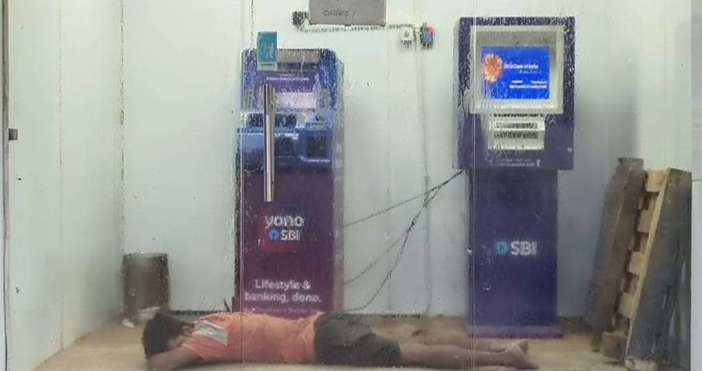 नगर के भीटी स्थित एसबीआई बैंक के एटीएम में सोता युवक:सोर्स सोशल मीडिया