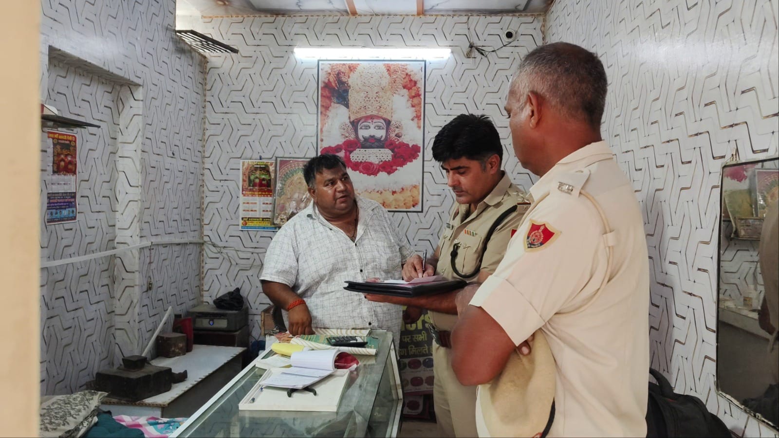पुलिस टीम दुकान पर जांच करते हुए। संवाद