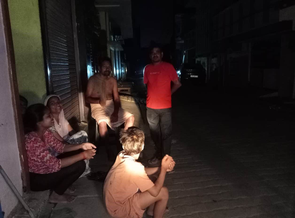 भंगवा चुंगी के समीप सियाराम कॉलोनी में बिजली न होने पर घर के बाहर बैठे गर्मी से बेहाल लोग। संवा
