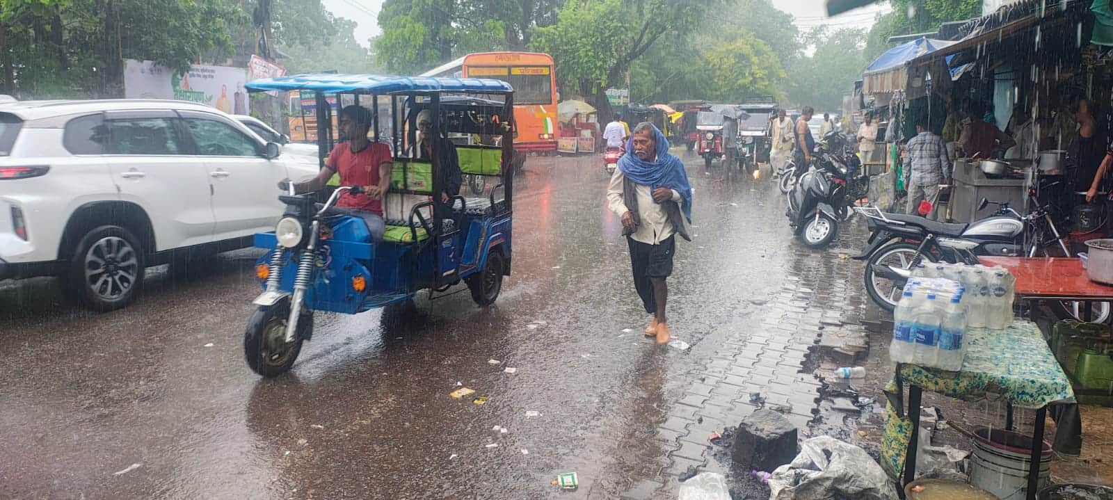 फोटो-10- शहर में बारिश के दौरान बस स्टैंड पर लोग बारिश से बचने के लिए परेशान नजर आए। संवाद
