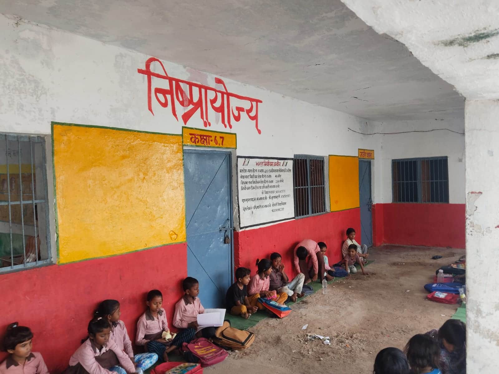 फोटो-15-जर्जर भवन पर अंकित निष्प्रयोज्य और नीचे ही बैठे बच्चे।