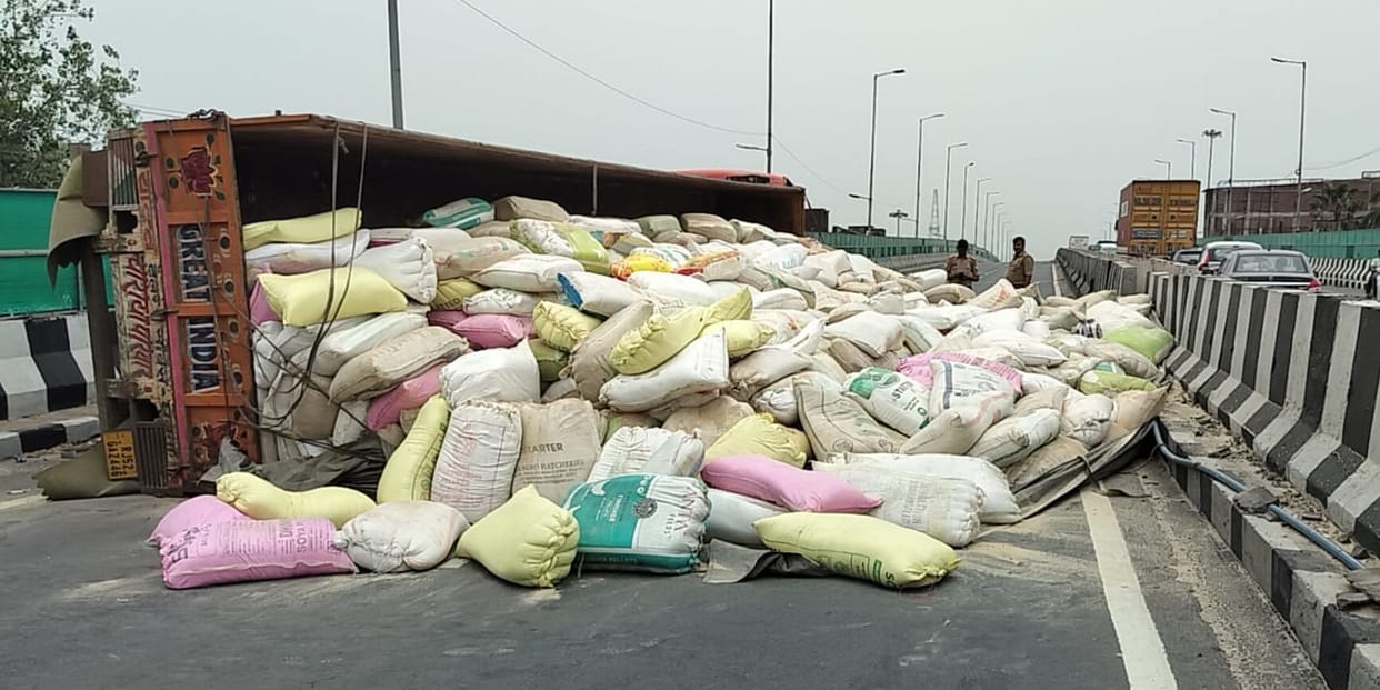 Container filled with animal feed overturns on overbridge; traffic disrupted for two hours.