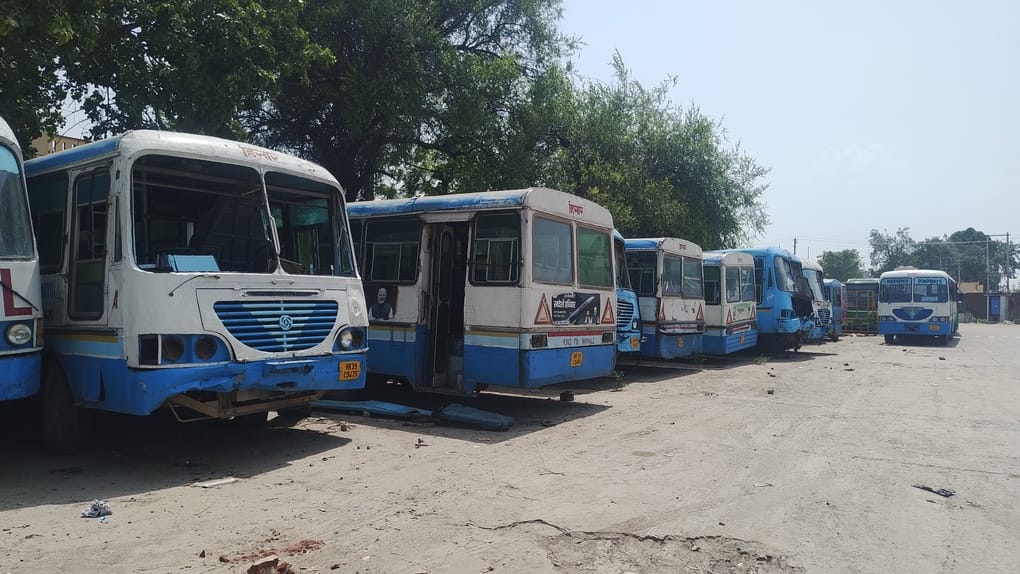 Wheels grind to a halt awaiting quotas; buses remain confined in the workshop.