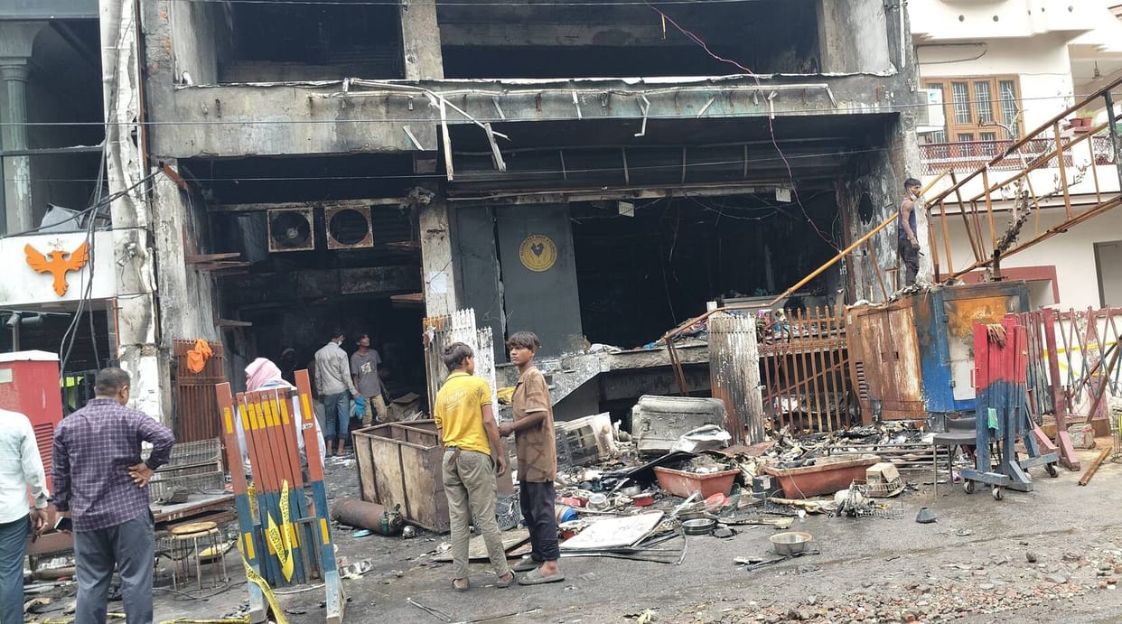Shopkeepers removing goods from the fire-hit building before its demolition.