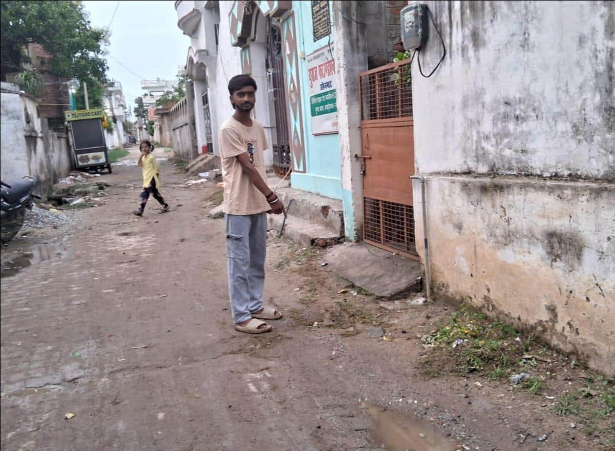 एचडीएफसी बैंक के सामने वाली गली में पानी रिसाव होने वाले स्थान को दिखाता युवक। संवाद