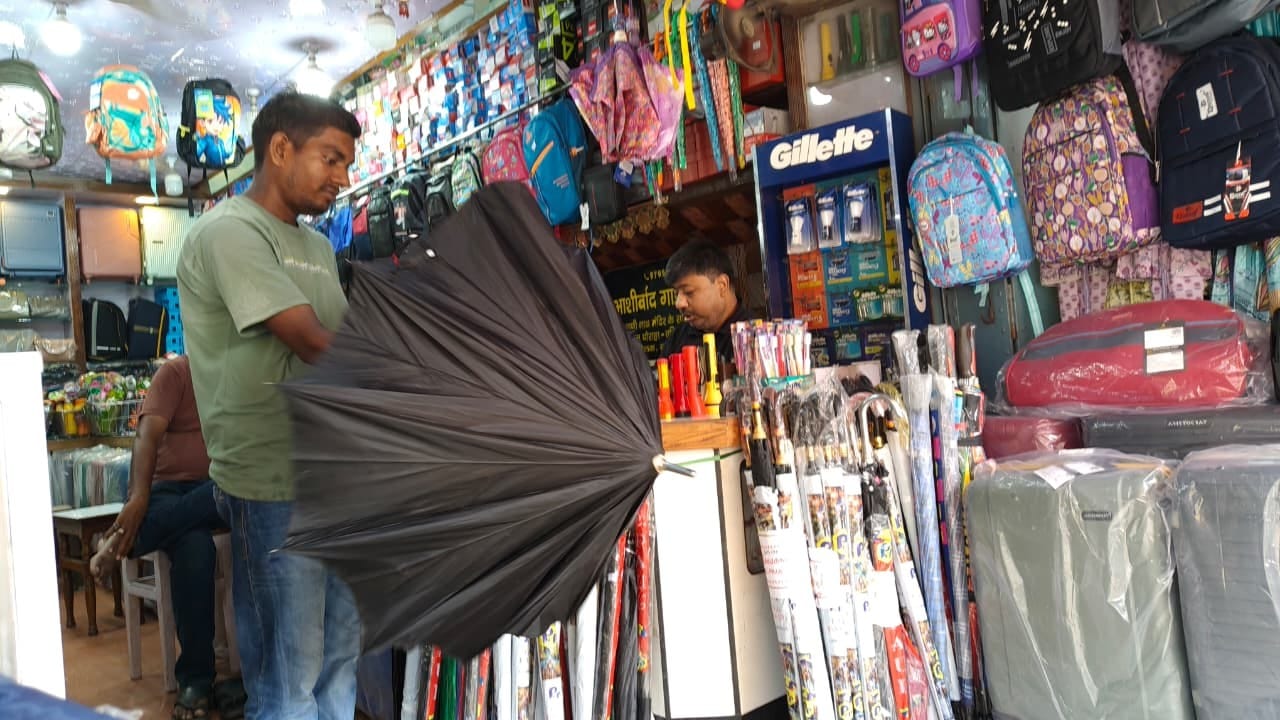 नगर के स्टेशन रोड पर छाता की खरीदारी करता युवक।संवाद
