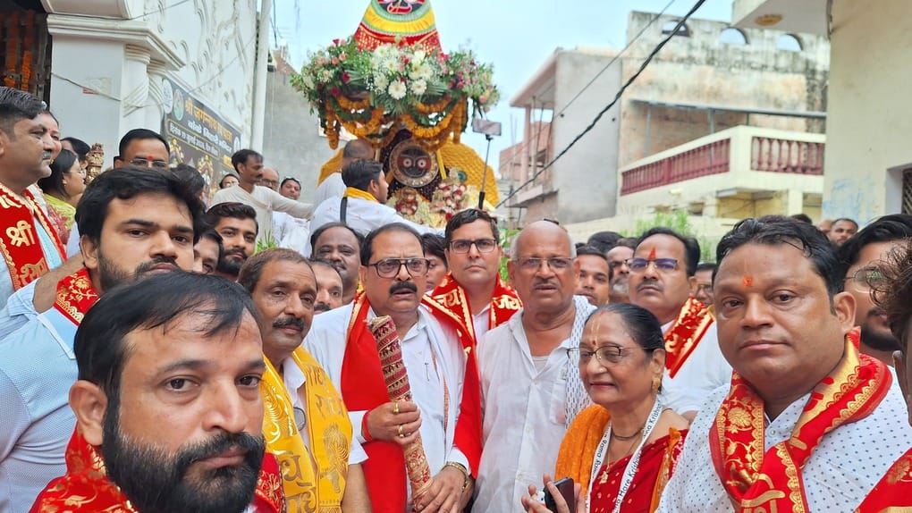 Lord Jagannath seated on a flower-adorned chariot; chants of devotion resound.