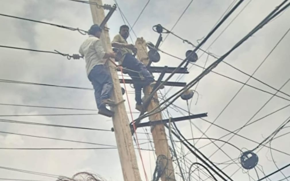 शहर में बिजली लाइनों पर काम कर रहे लाइनमैन।