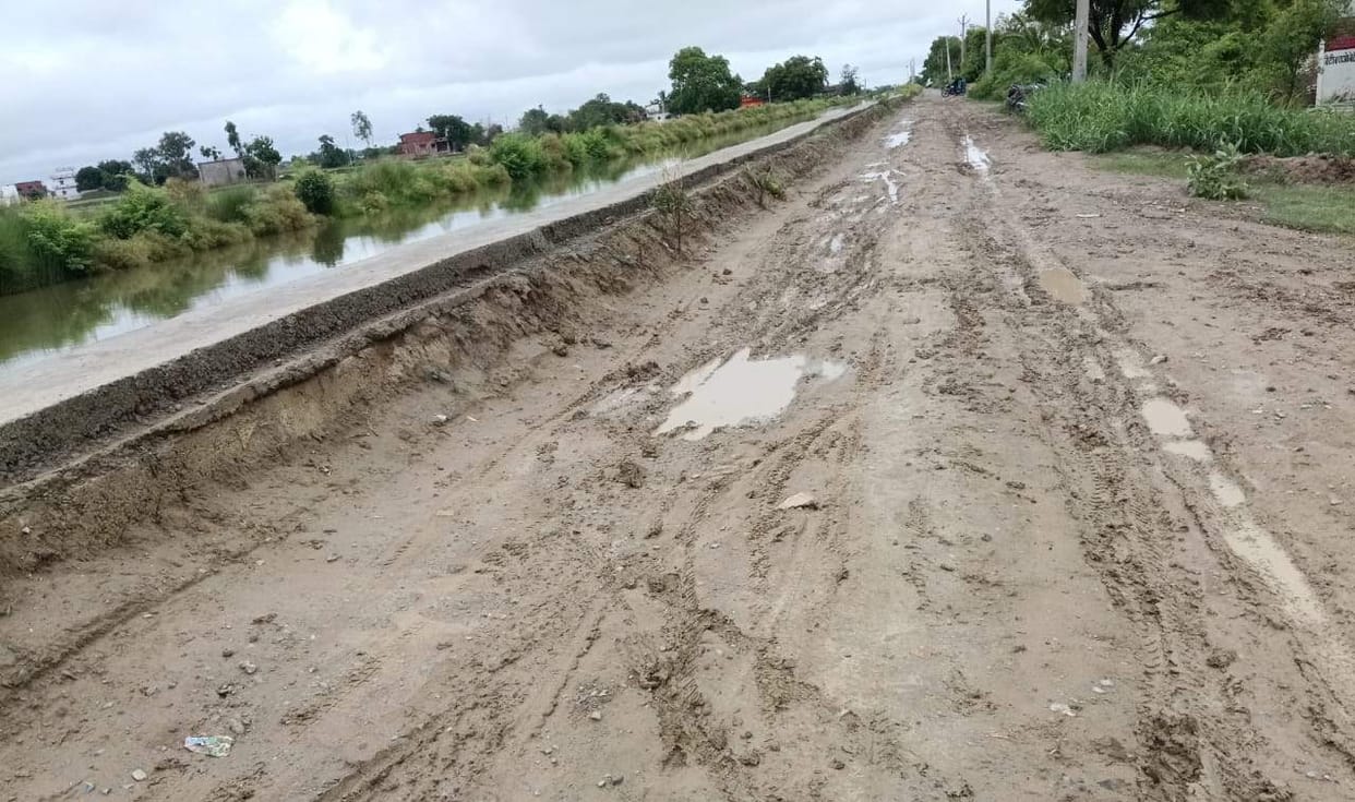 Canal silt dumped on the road; risk of accidents.