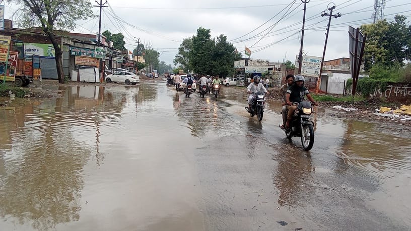 बारिश के बाद शहर के कैराना रोड पर हुए जलभराव के बीच से गुजरते वाहन चालक। संवाद