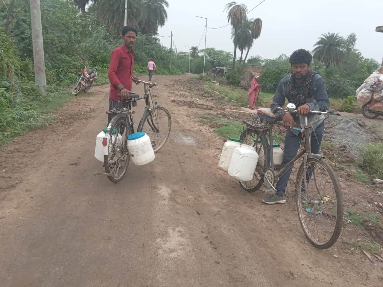 फोटो-12- मटौंध कस्बे में साइकिल से पानी ढोते ग्रामीण। संवाद
